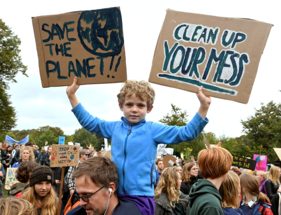 A child holds placards during a protest march to call for action against climate change, in The Hague, Netherlands September 27, 2019. REUTERS/Piroschka van de Wouw